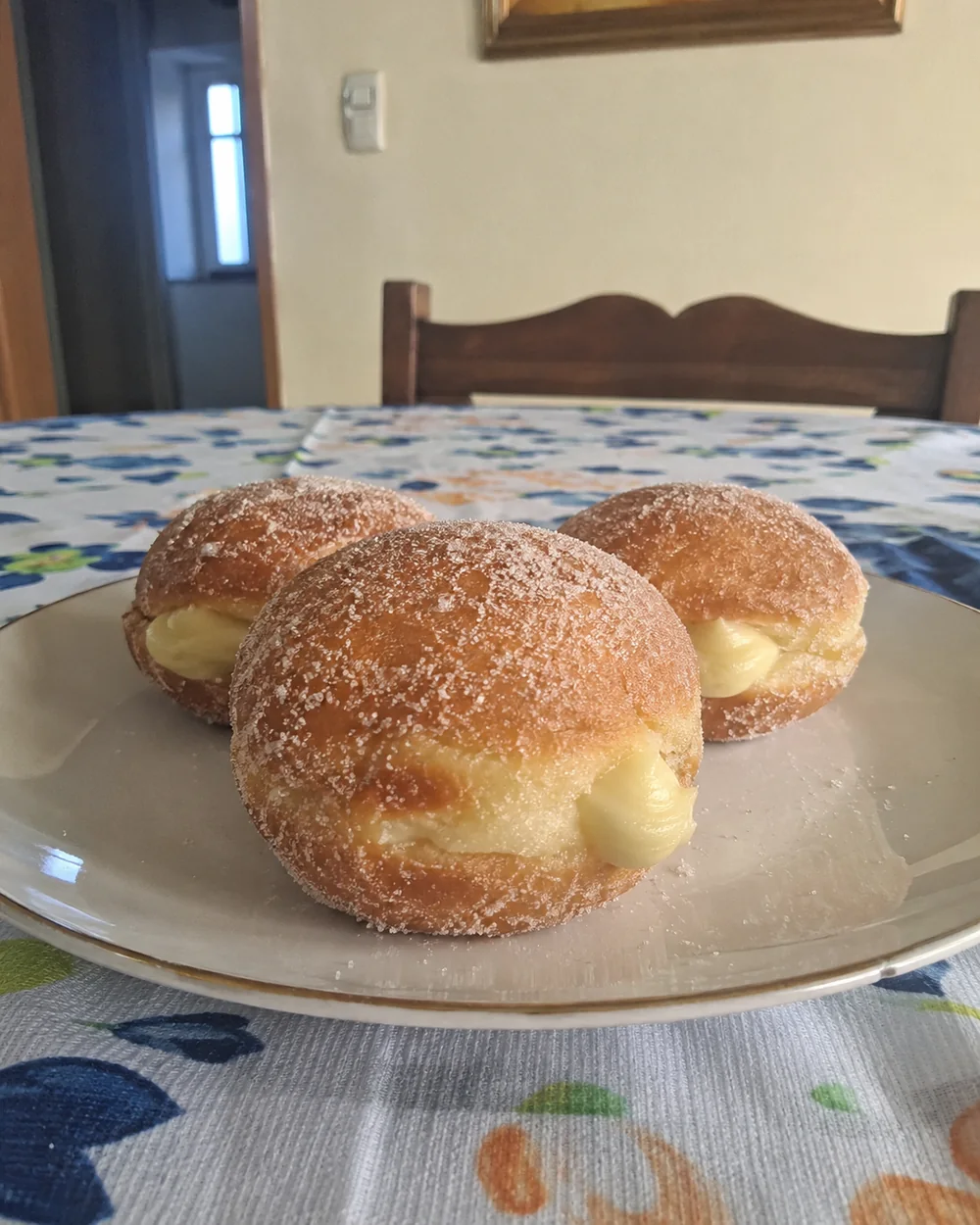 Três bomboloni italianos caseiros recheados com creme