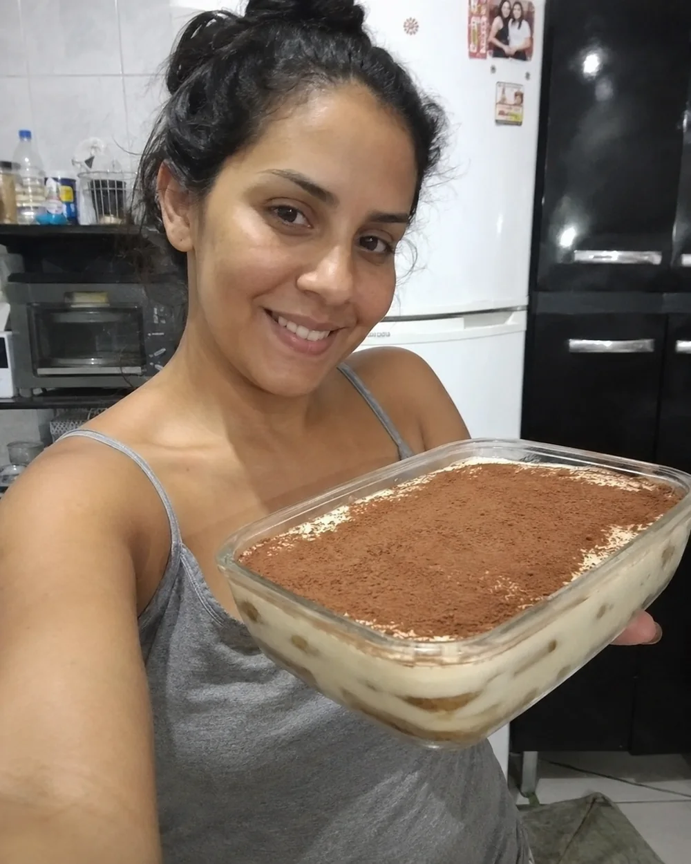 Cliente mostrando uma travessa de tiramisù italiano preparado em casa