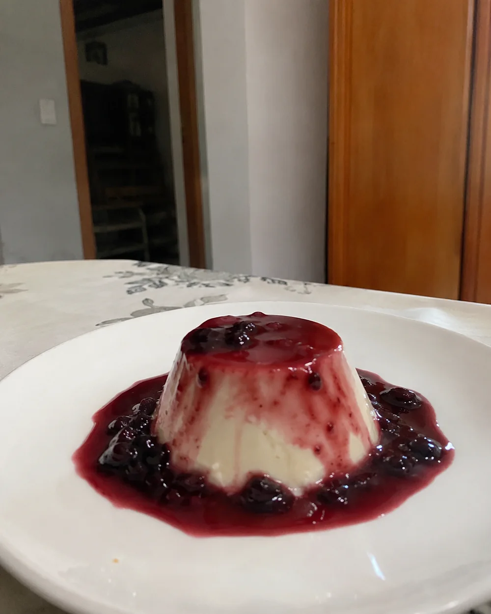 Panna cotta caseira coberta com calda de frutas vermelhas